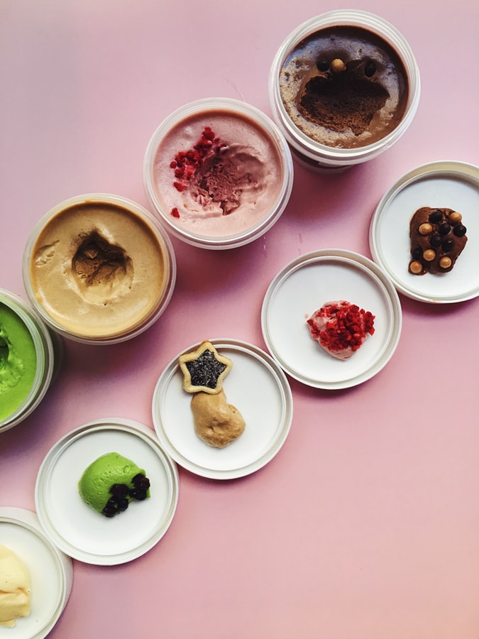 A picture of five different tubs of ice-cream of different flavours and colours