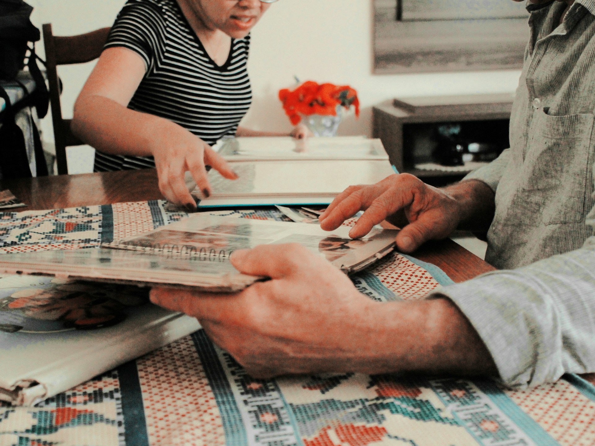 A parent holding a folder of documents while a child plays in the background